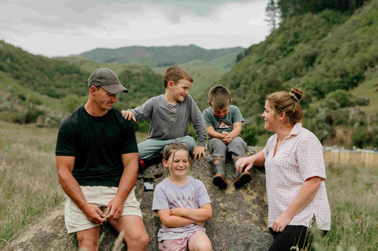 a young happy healthy family, posing for a group photo in a lovely rural setting on a manuka honey farm
