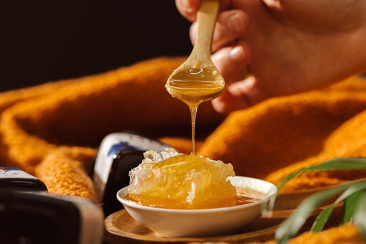 Delicious M&H Manuka Honey drizzling from a spoon into a bowl.