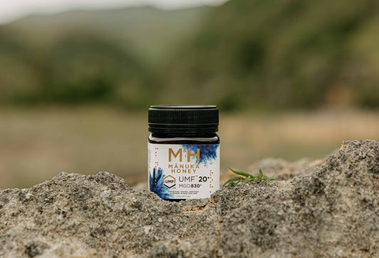 M&H NZ manuka honey jar with natural mountain landscape behind