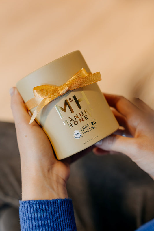 a woman holding a manuka honey gift box
