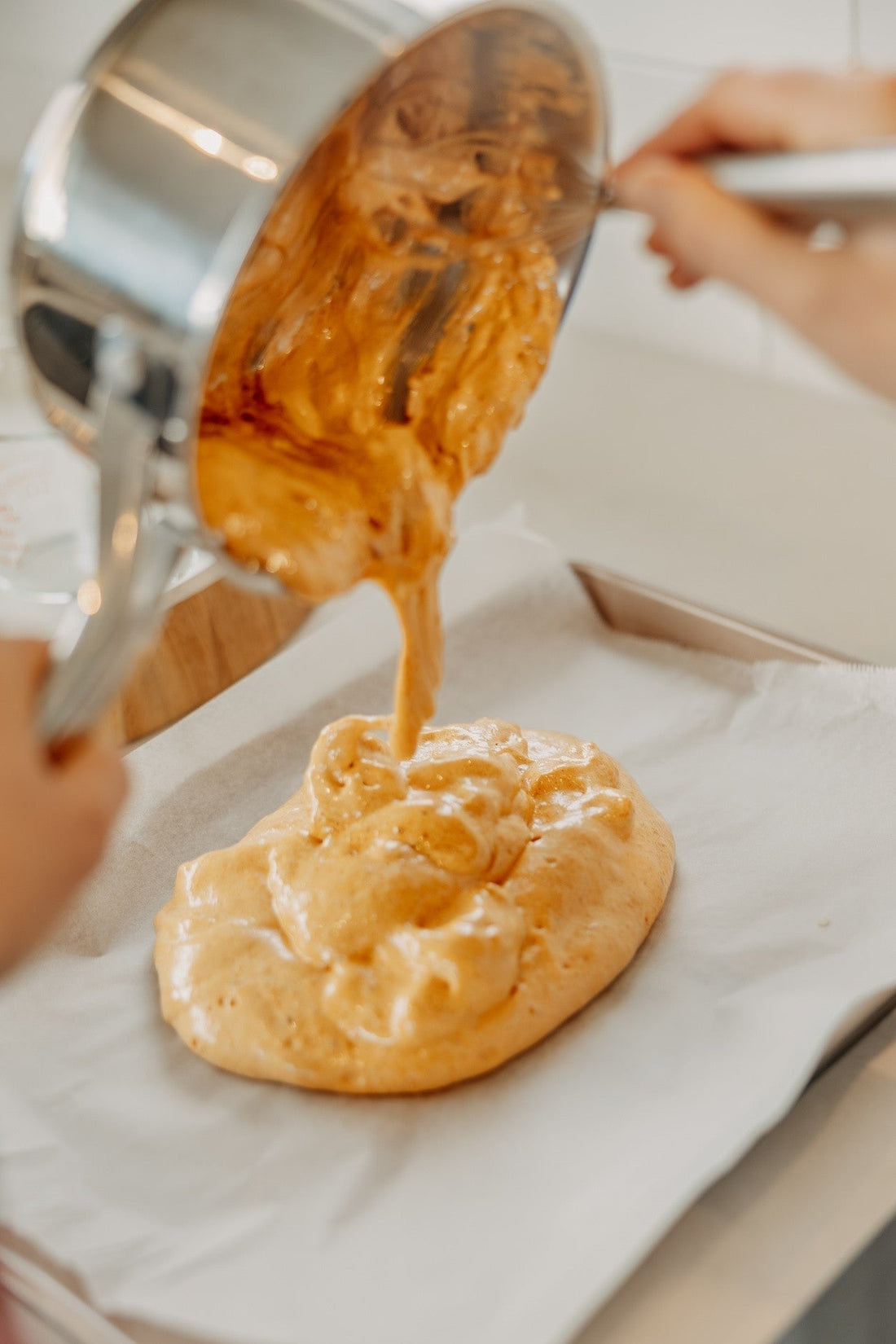 pouring hokey pokey (honeycomb) from a cooking pot onto baking paper