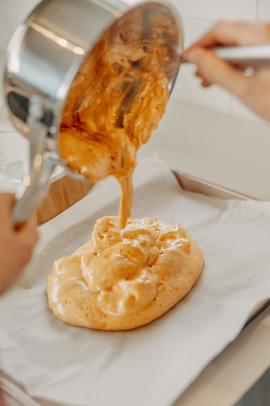 pouring hokey pokey (honeycomb) from a cooking pot onto baking paper