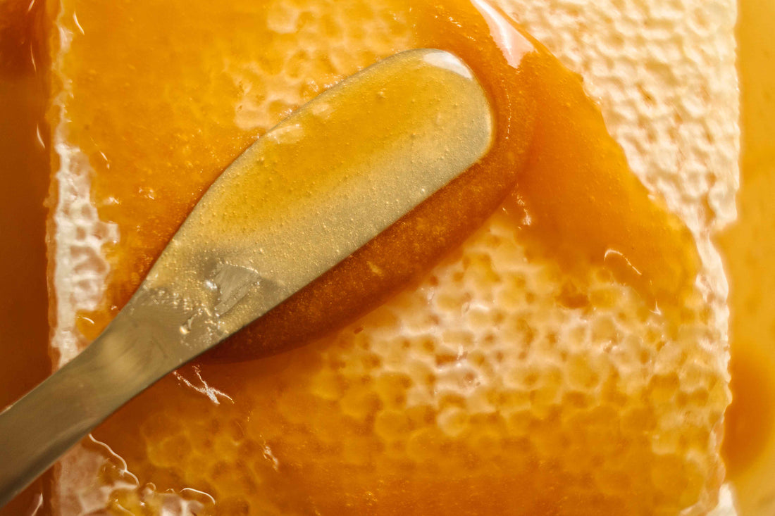spreading honey over honeycomb with a butter knife